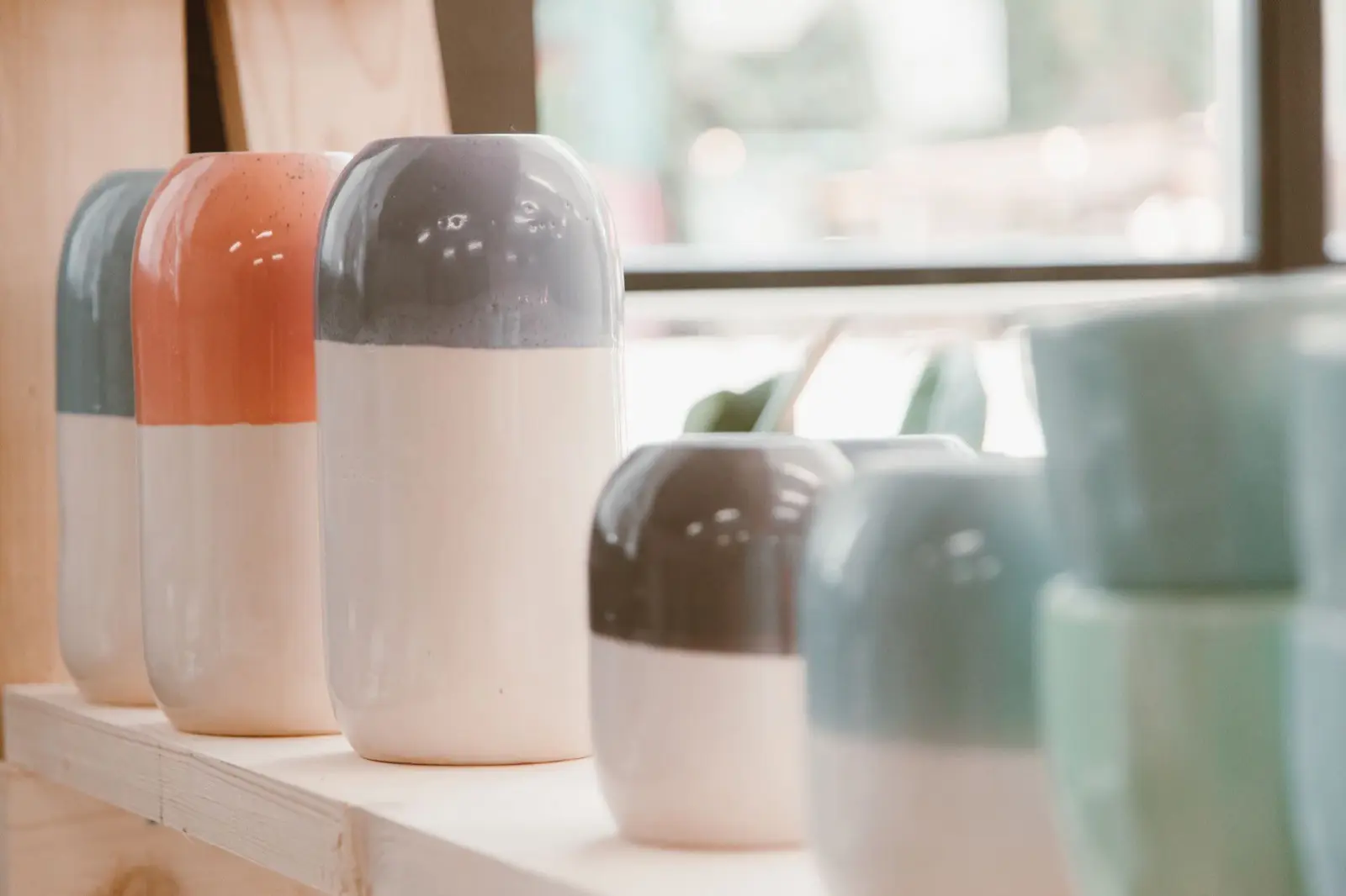 Vazen in verschillende kleuren op een houten plank